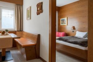 1 dormitorio con cama, mesa y ventana en A. Paolo Apartments, en Vigo di Fassa