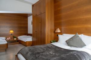 una camera con un grande letto e pareti in legno di A. Paolo Apartments a Vigo di Fassa