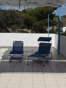 two chairs and tables sitting on a patio at Giota & Antonia Apartments in Koroni