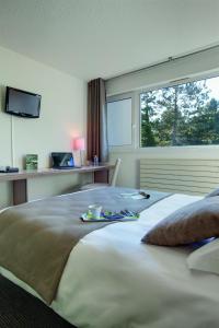 Un pat sau paturi într-o cameră la Hotel Belambra Le Normont