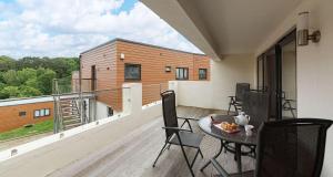 a balcony with a table and chairs on a deck at Plover 3 - The Cove in Brixham