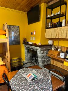 een woonkamer met een open haard en een tafel en stoelen bij B&B Il Nido in Riolunato