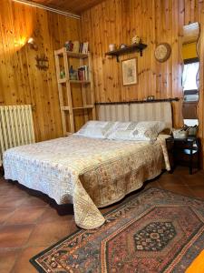a bedroom with a bed in a room with wooden walls at B&B Il Nido in Riolunato