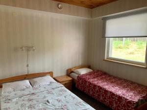 a bedroom with two beds and a window at Holiday Home Veskijõe in Vaisi