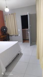 een witte slaapkamer met een bed en een raam bij Pousada Mariza in Guarabira