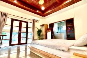 Schlafzimmer mit einem großen weißen Bett und Fenstern in der Unterkunft Lake & lotus ponds view 2nd floor Villa in Thongsala