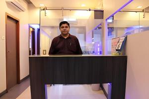 a man standing at a counter in a room at Apollo Guest House in Mumbai