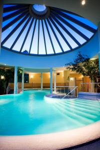 a large swimming pool with a blue ceiling at Hotel Allmer in Bad Gleichenberg