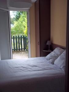 a bedroom with a bed and a large window at Arcachon T2 Calme proche plages et commerces et 2 vélos in Arcachon