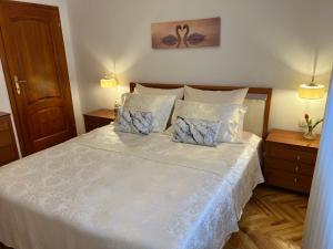 1 dormitorio con 1 cama blanca y 2 almohadas en Villa HOPE, en Zmijavci