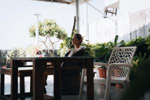 a woman sitting at a table in a garden at JHouse near Bhikaji in New Delhi