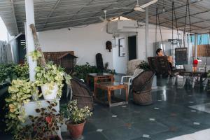 una persona sentada en una silla en una habitación con plantas en JHouse near Bhikaji, en Nueva Delhi