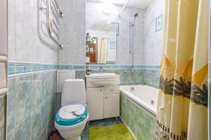 a bathroom with a toilet and a sink and a tub at Уютная квартира in Astana