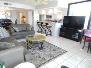 sala de estar con sofá, TV y mesa en "SHERWIN" Coastal Vibes Oceanfront Condominiums en Daytona Beach