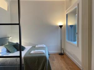 a bedroom with a bed and a floor lamp at LOFT sull'acqua con vista mozzafiato in Naples
