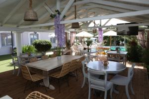 un comedor con mesas, sillas y flores púrpuras en Caretta - Caretta Hotel, en Ligia
