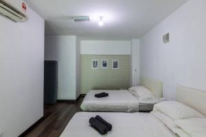 two beds in a room with white walls and wood floors at 2bedrooms Maritime Seaview Luxury Suite 2Carpark 2-9pax in Jelutong