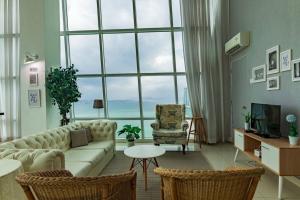 a living room with a couch and a large window at 2bedrooms Maritime Seaview Luxury Suite 2Carpark 2-9pax in Jelutong