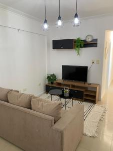 a living room with a couch and a flat screen tv at Departamento Centro in Santiago del Estero