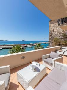 Un balcón con sillas blancas y vistas al océano. en Villa Ana Apartments, en Mlini