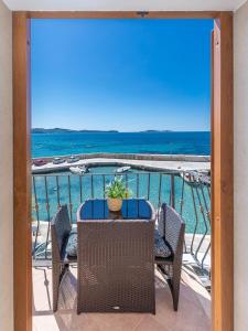 Villa Ana Apartments في مْليني: طاولة وكراسي على شرفة مطلة على المحيط