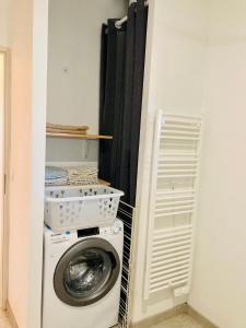 eine Waschküche mit Waschmaschine in einem Zimmer in der Unterkunft Appartement Riquet - centre ville, rdc, climatisé, jardin, parking privée in Castelnaudary