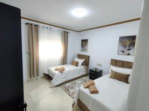 1 dormitorio con 2 camas y ventana en Merveilleux Appartement pour un séjour de Top., en Tánger