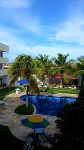 阿基拉斯的住宿－Hotel Pousada Summer Way，一个带棕榈树和遮阳伞的游泳池