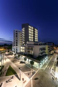 Hesperia Hotel & Residence في ليدو دي يسولو: مبنى كبير في مدينة في الليل