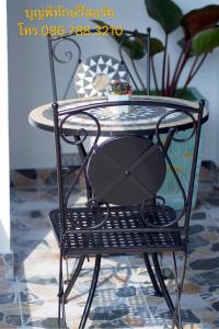 a black metal chair with a glass table at บุญพิทักษ์รีสอร์ท in Thung Saliam