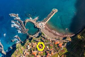 an island with a yellow house in the middle of the ocean at Casa Das Videiras in Seixal