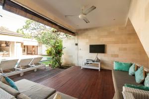 a living room with a couch and a tv at Lovely Canggu 4BR Private Pool Villa with Sundeck! 10mins Ride to Beach in Canggu