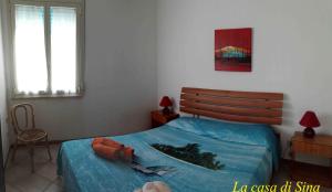 a bedroom with a bed with a blue blanket and a window at La casa di Sina in Marsala