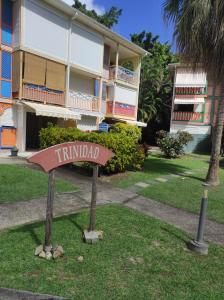 un panneau dans l'herbe devant un bâtiment dans l'établissement MANOU, à Sainte-Anne