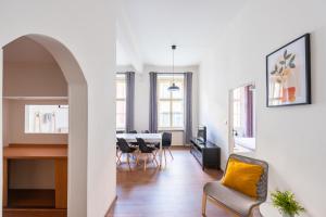 een woonkamer met een tafel en stoelen en een eetkamer bij Budget Reznicka apartment in Praag