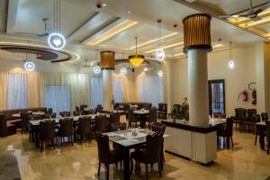 a restaurant with tables and chairs in a room at Flamingo Club and Resort Una 3 Km Away from Diu Check Post in Diu