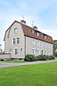 un grand bâtiment blanc avec un toit rouge dans l'établissement Vallarnas Bed & Breakfast, à Falkenberg