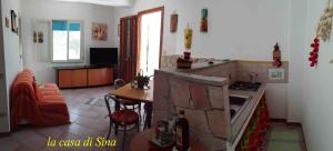 a kitchen with a stove and a table in a room at La casa di Sina in Marsala