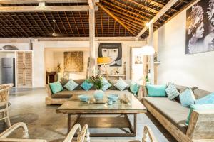 a living room with a couch and a table at Lovely Canggu 4BR Private Pool Villa with Sundeck! 10mins Ride to Beach in Canggu