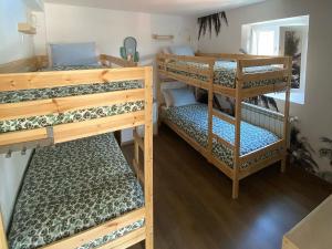 a room with three bunk beds in it at COCOS SURFHOUSE in San Juan de la Arena