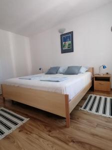a bedroom with a large bed with white sheets at Apartman Nora in Hvar