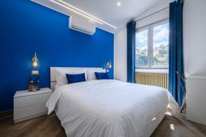 a blue bedroom with a white bed and a window at Villa In Bed in Naples