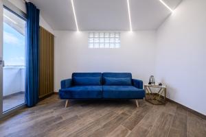 um sofá azul num quarto com uma janela grande em Villa In Bed em Nápoles
