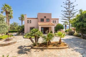 ein Haus mit Palmen davor in der Unterkunft Modern Villas with gardens and stunning views in Ligaria