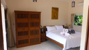 a bedroom with a bed and a dresser at Khao Sok Jasmine Garden Resort - SHA Certified in Khao Sok National Park
