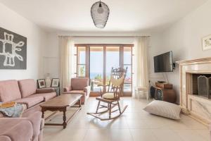 ein Wohnzimmer mit einem Sofa und einem Kamin in der Unterkunft Modern Villas with gardens and stunning views in Ligaria