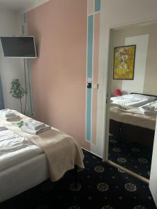 オストラヴァにあるBrioni Boutique Hotel 4*のベッド2台と鏡が備わるホテルルームです。