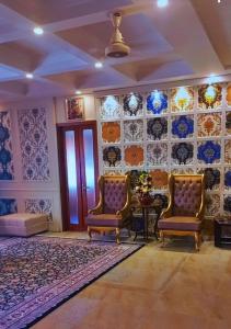 a living room with two chairs and a table at BED AND BREAKFAST ISLAMABAD - cottages in Islamabad
