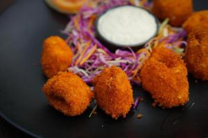 a plate of food with some fried food and coleslaw at The Alina Hotel & Suites in Chittagong