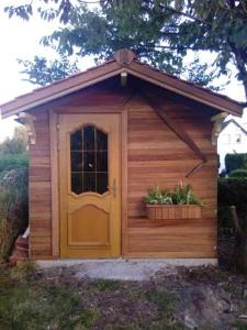 drewniana buda dla psa z drzwiami i dwiema roślinami w obiekcie Maison de campagne Conchil le temple w mieście Conchil-le-Temple